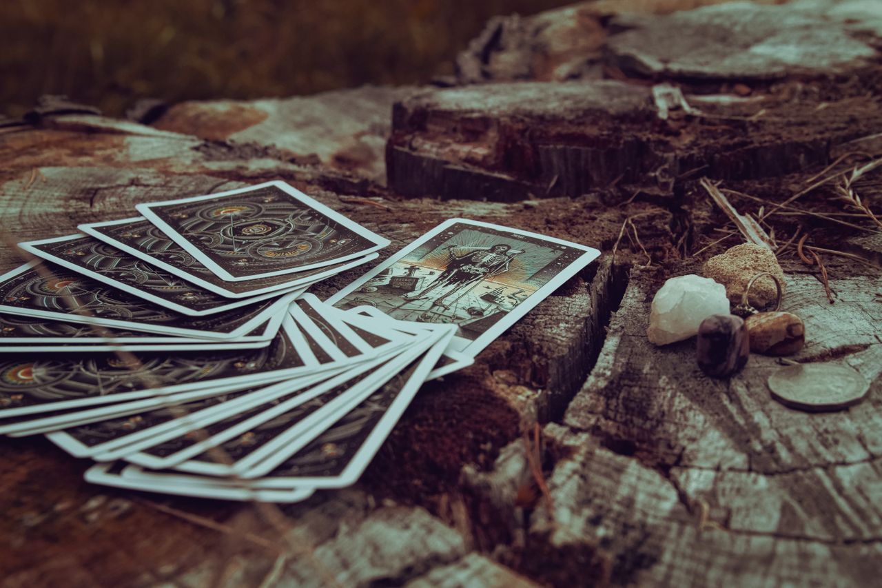 A spread of tarot cards placed on an ancient tree stump, evoking mystery and spirituality.
