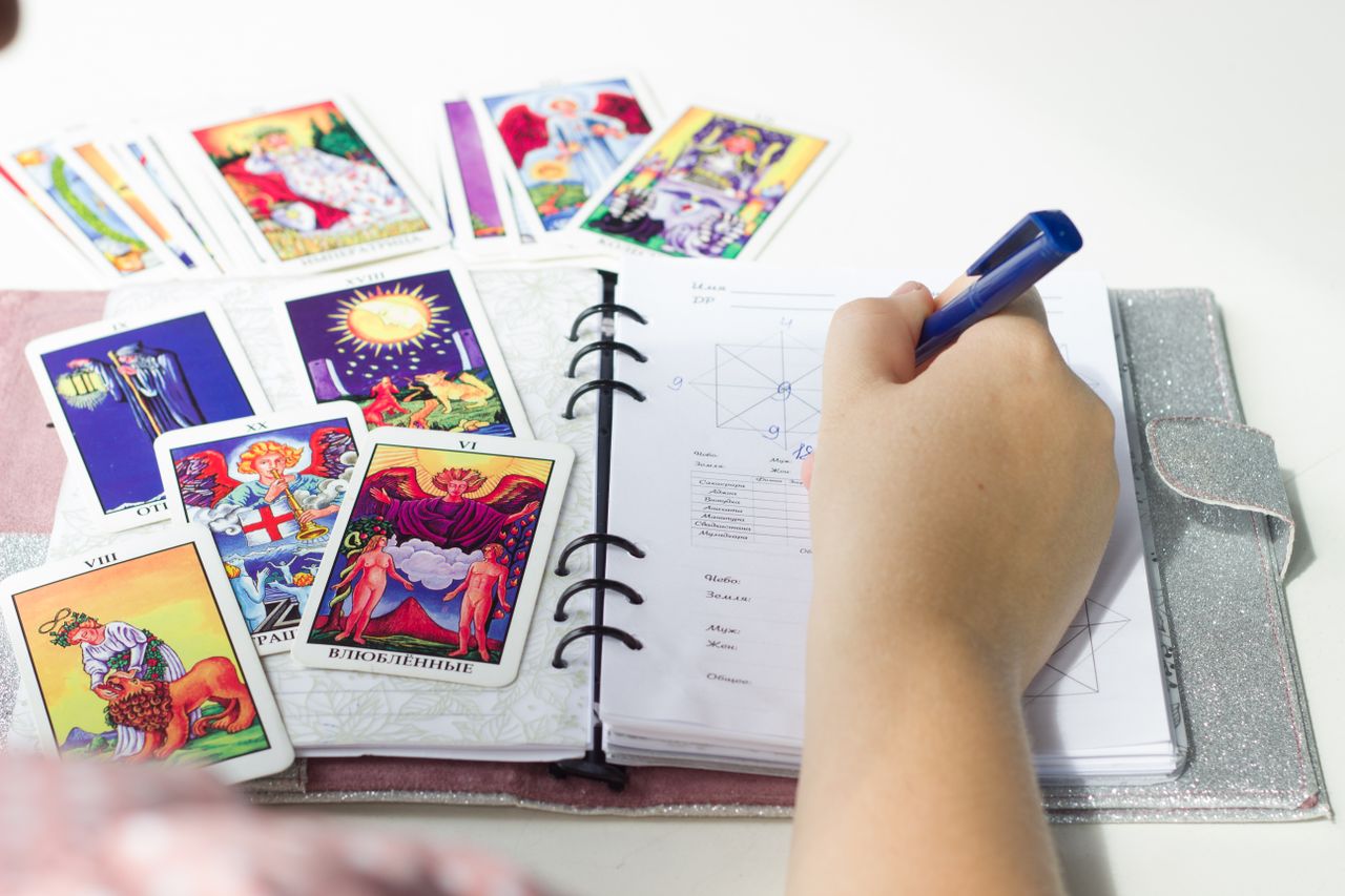 Colorful tarot cards and journal writing, signifying a tarot card reading session.